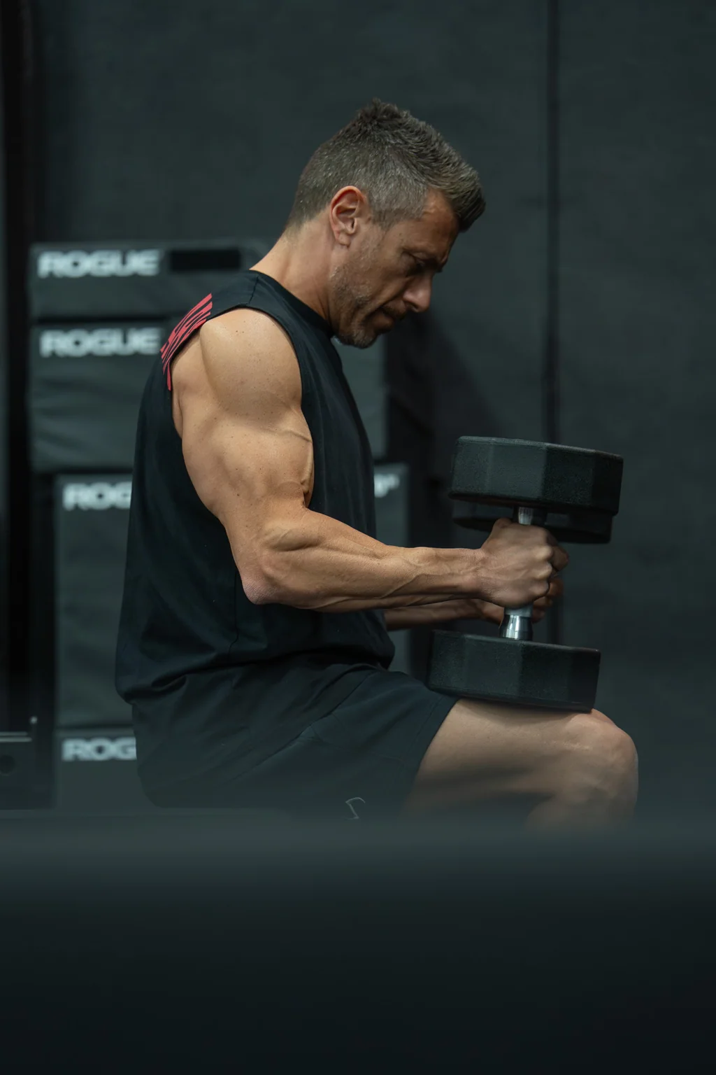A seated dumbbell curl in a gym.
